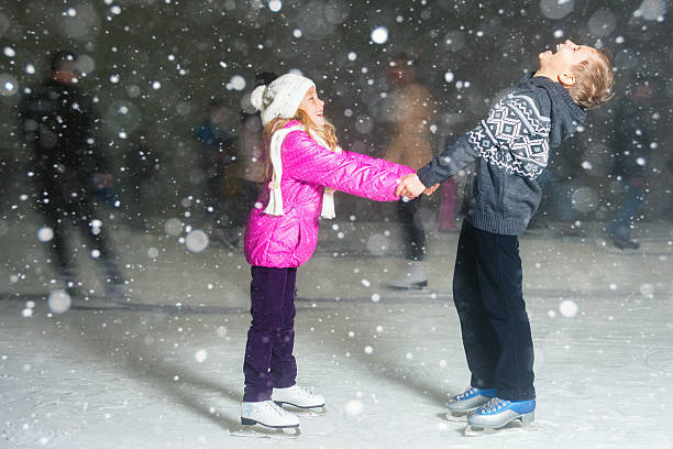 glückliche kinder eislaufen im eisstadion, winter nacht - ice skating ice hockey child family stock-fotos und bilder