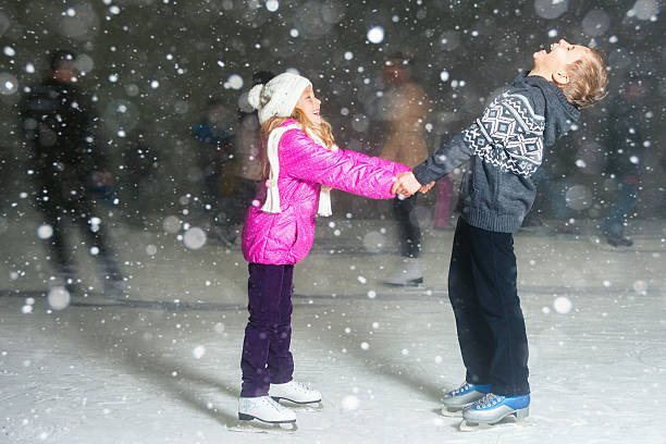 crianças felizes de patinagem em pista de patinagem no gelo, de inverno noite - ice skating ice hockey child family imagens e fotografias de stock