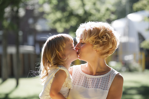 Mother and daughter a kiss on the lips