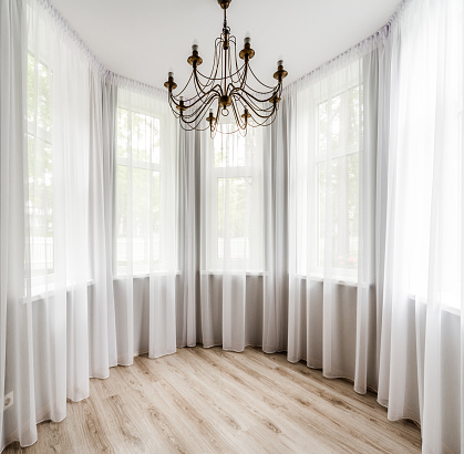 Elegant room interior with wooden floor, white curtain and chandelier