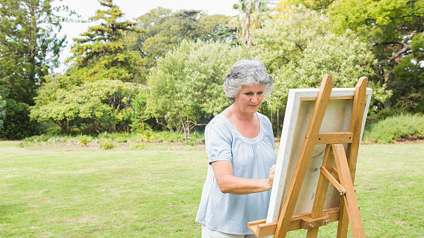 istock Peaceful retired woman painting on canvas 499812111