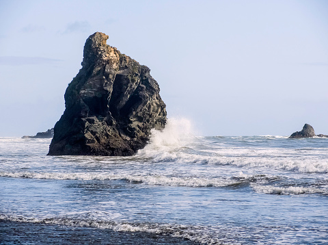 Seastack hit by wave at Ruby Beach in Olympic National Park, Washington, USA, near sunset