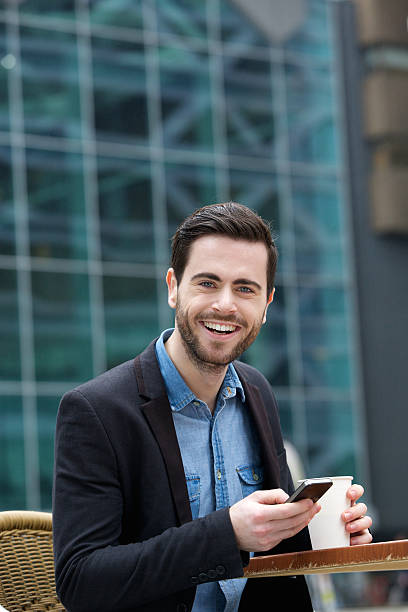istock Cute guy smiling with mobile phone 499842883