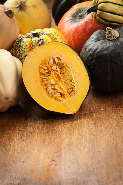 Variety of Winter Squashes Vertical with Copy Space Subject: A row of fall squash with copy space for custom text. acorn squash stock pictures, royalty-free photos & images