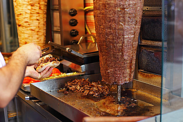 cook preparing a turkish doner kebab - döner stok fotoğraflar ve resimler