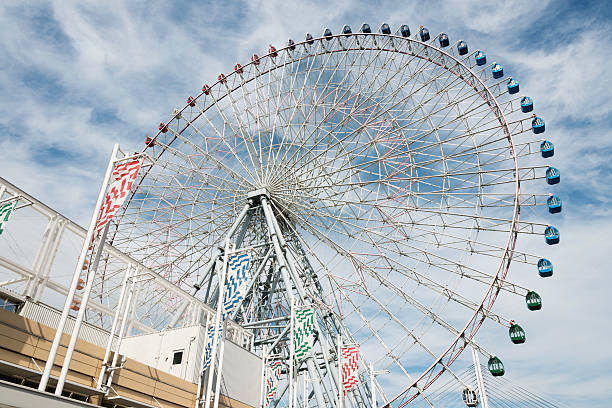 Giant Ferris Wheel against a cloudy dramatic sky in Osaka, Japan.