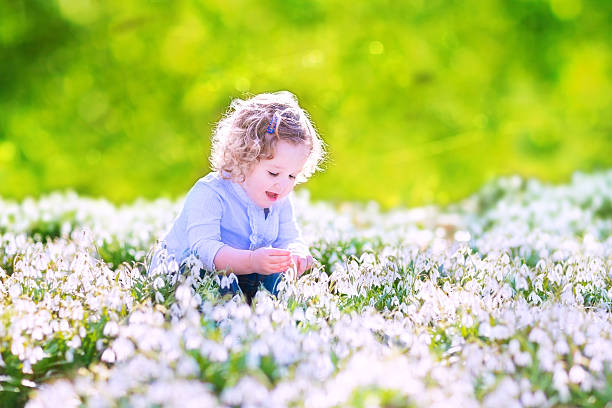 istock Happy girl playing with first spring flowers 499845819
