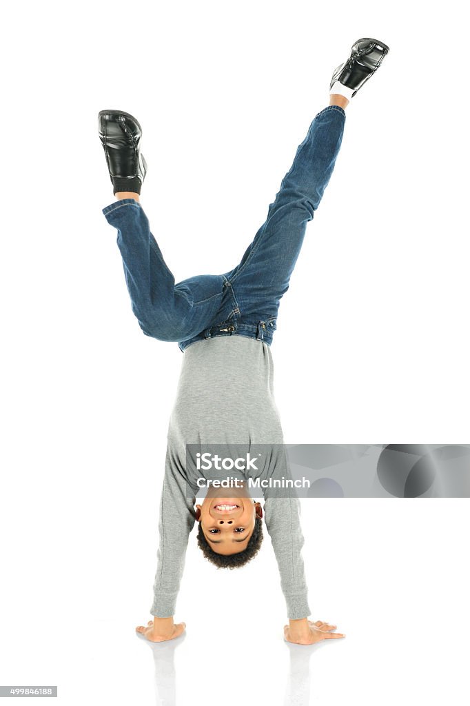Happiest Upside Down An elementary boy deslightedly standing on his hands.  On a white background. Upside Down Stock Photo