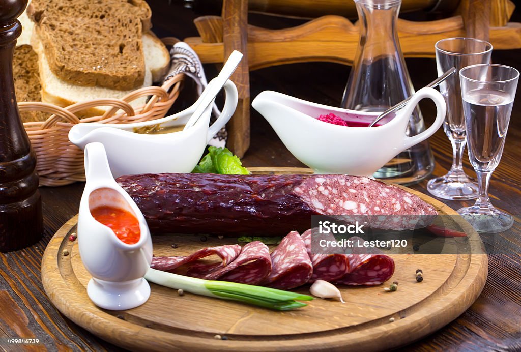 plate with sausage sausage on a wooden plate in a restaurant Beef Stock Photo