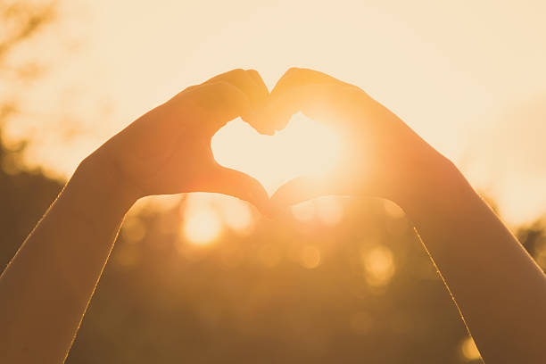 istock hands forming a heart shape at sunset 499849434