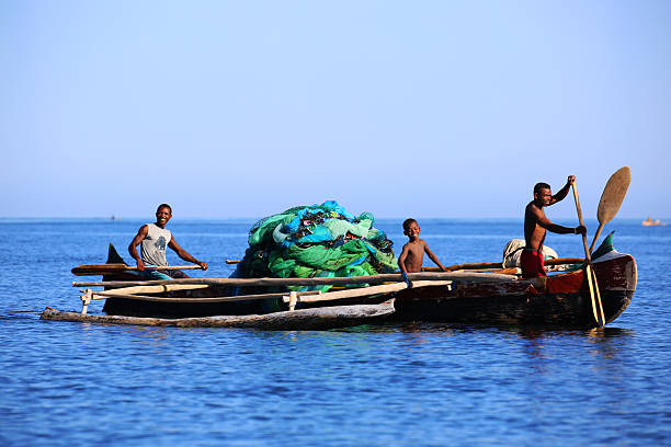 Madagascar: Fishing in the Mozambique Channel Ifaty, Madagascar - August 5, 2015: Fishermen paddle their dugout canoe to open waters off the coast of Ifaty in the Mozambique Channel. mozambique channel stock pictures, royalty-free photos & images