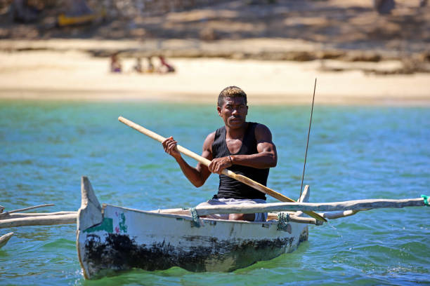 Madagascar: Fishing in the Mozambique Channel Ifaty, Madagascar - August 5, 2015: A fishermen paddles his dugout canoe off the coast of Ifaty in the Mozambique Channel. mozambique channel stock pictures, royalty-free photos & images