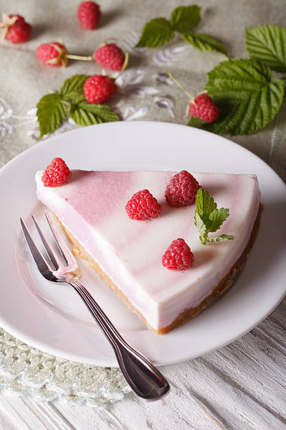 piece of raspberry cheesecake close-up on a plate. vertical top
