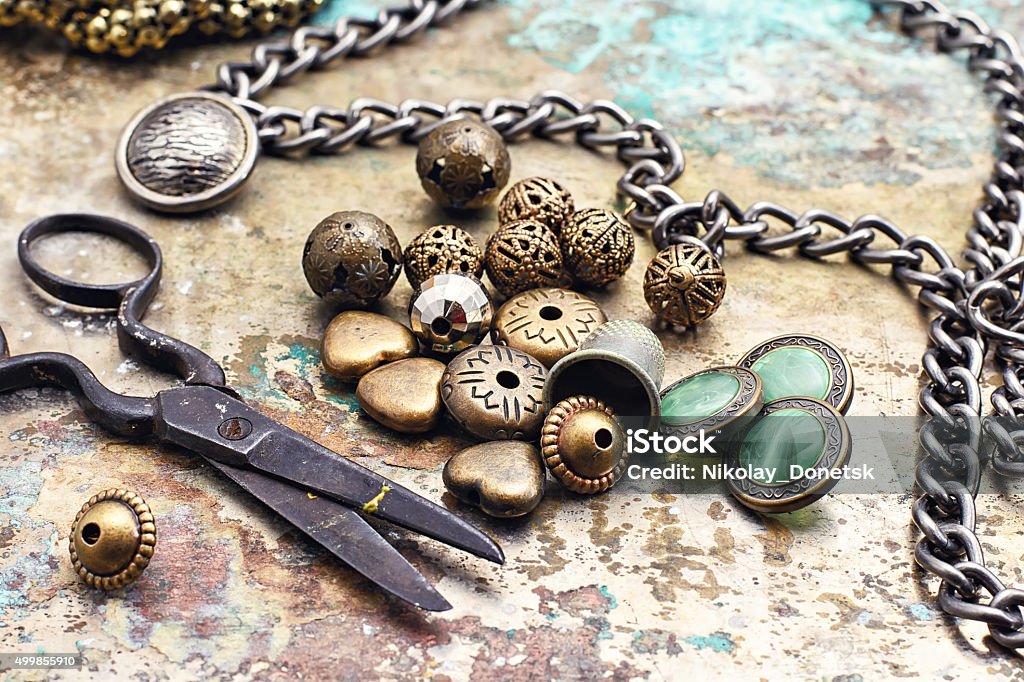 fashion accessory for needlework Metal beads,buttons,chain and scissors on retro background Button - Sewing Item Stock Photo