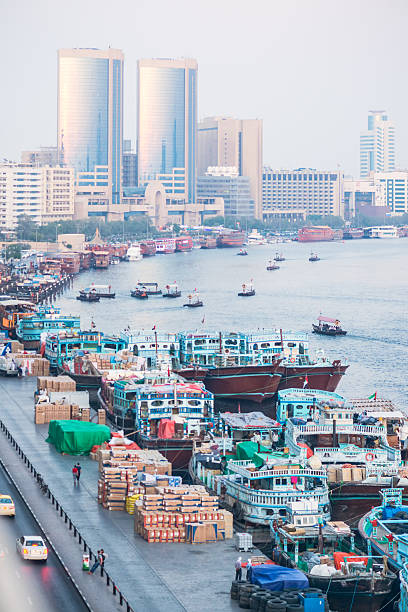 Dubai iStockalypse.  Dubai Creek in the evening. Old traditional wooden dhows in the foreground loading and unloading cargo with foreign crew living aboard.  Abra boats transport passengers across the creek in the midground.  Dinner cruise boats wait for diners in the background with modern offices and hotels behind.  Deira District, Dubai, UAE.