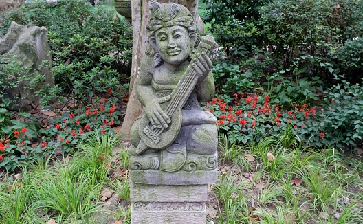 Headshot of wooden female thai statue with Wai gesture welcoming people at cultural old house in On Tai, Chiang Mai, San Kamphaeng district of Chiang Mai