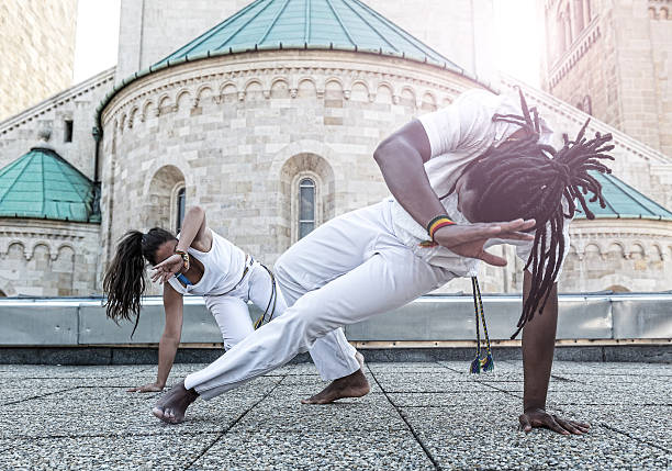 jeune couple faire de la capoeira partenariat, spectaculaire sport - horizontal black and white toned image two people photos et images de collection