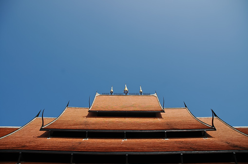 Ceramics roof of Thai temple under blue sky
