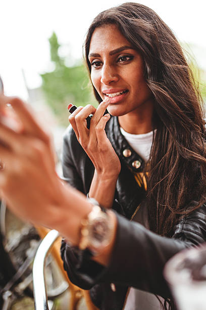 istock woman using make-up outdoors 499872703