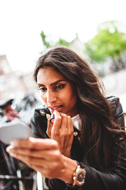 istock woman using make-up outdoors 499872709