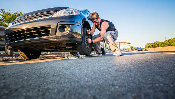 istock Man changing the flattened tyre at the highway 499872963