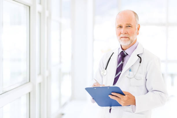 istock Confident Senior Doctor Writing On Clipboard 499873603