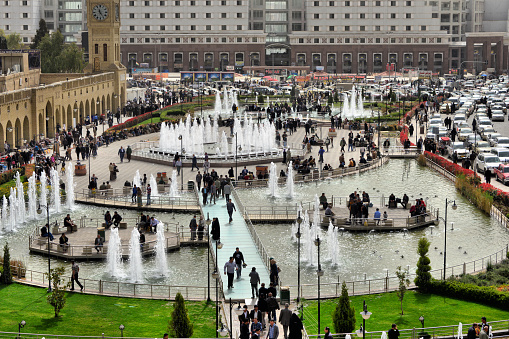 Erbil / Hewler / Arbil / Irbil, Kurdistan, Iraq: main square, Shar Park, with crowds enjoying the pleasantly cool area created by the walkable fountains - arcades on both sides and Nishtiman shopping mall in front - seen from the Erbil citadel - photo by M.Torres