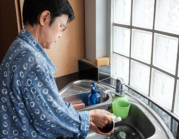 istock Thai woman cleaning cups at the kitchen sink 499874428