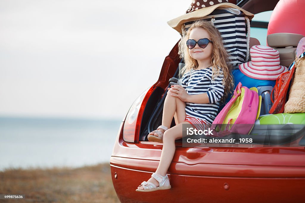 La chica y equipaje en el tronco abierto - Foto de stock de Coche libre de derechos