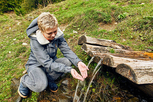 istock Girl drinks water from a mountain spring 499877918