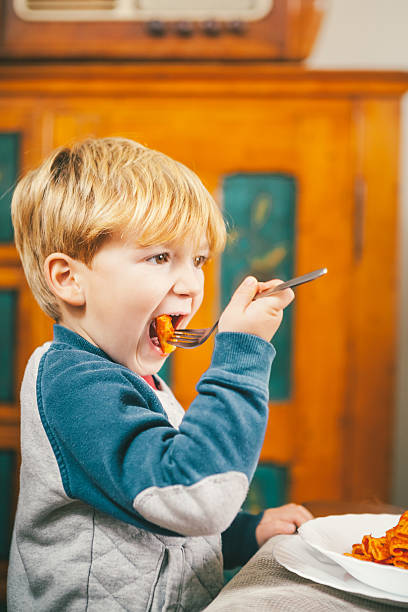 istock Child Eating Pasta at Christmas Dinner 499877938