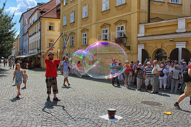Prague, Czech Republic – August 3, 2014: The photo depicts a local resident, to inflate large bubbles. On this show going to see tourists and children.