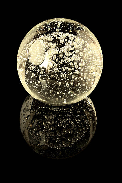 istock Glass ball with inner bubbles on a black mirror surface 499881578