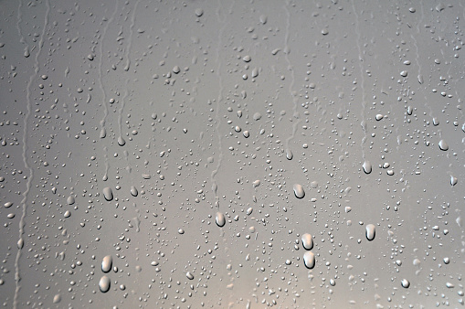 Raindrops separated out on a metal rail.