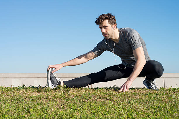 istock man stretches leg in the ground 499884762