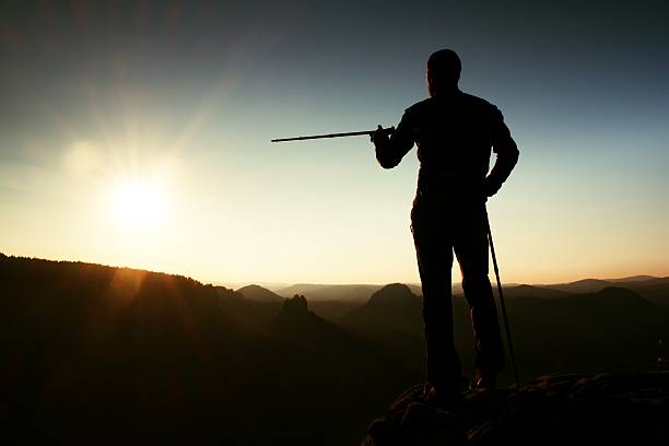 istock Guide show way with pole in hand. Hiker with backpack 499885508