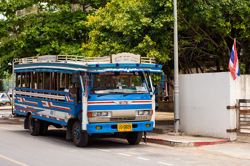 Phuket, Thailand - April 26, 2014: Blue local bus in Phuket, Thailand. The bus is at the bus station on Kata beach and it's waiting for its turn to carry passengers to Phuket town