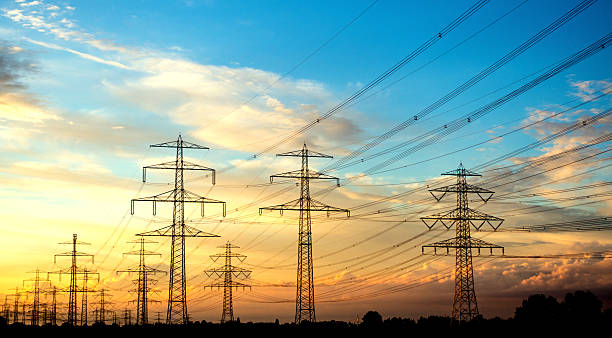 Electricity industry - many high voltage towers at sun set Electricity industry power mast stock pictures, royalty-free photos & images