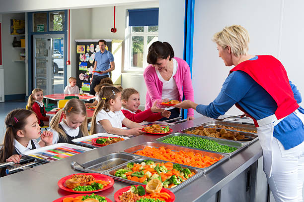 School Caferteria Line Dinner is served to children as they line up at a school canteen cafeteria stock pictures, royalty-free photos & images
