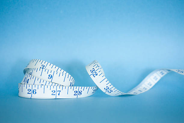 istock Measuring Tape Curled Againts Blue Background 499889425