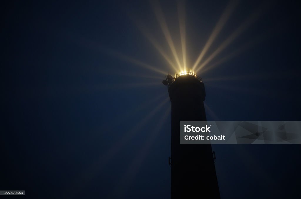 Old lighthouse in the fog with radial light beams Norderney lighthouse in the fog with radial light beams Built Structure Stock Photo