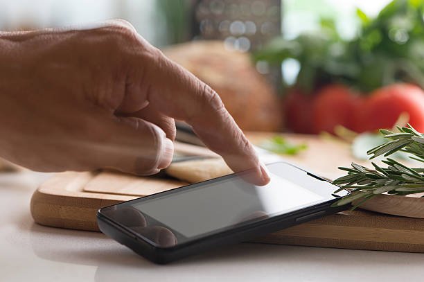 istock Cooking with a mobile phone with touching finger 499891181
