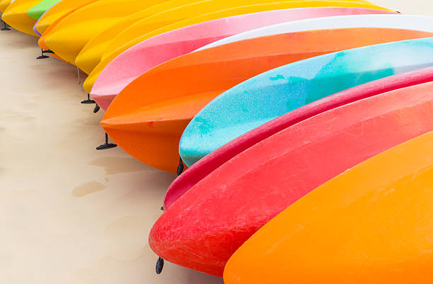 Many colorful kayaks orderly dock on the beautiful beach