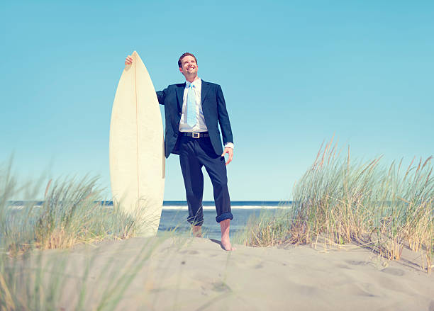 istock Businessman with Surfboard Standing by the Beach 499895855