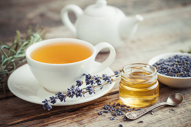 Healthy tea cup, honey, dry lavender flowers and teapot stock photo
