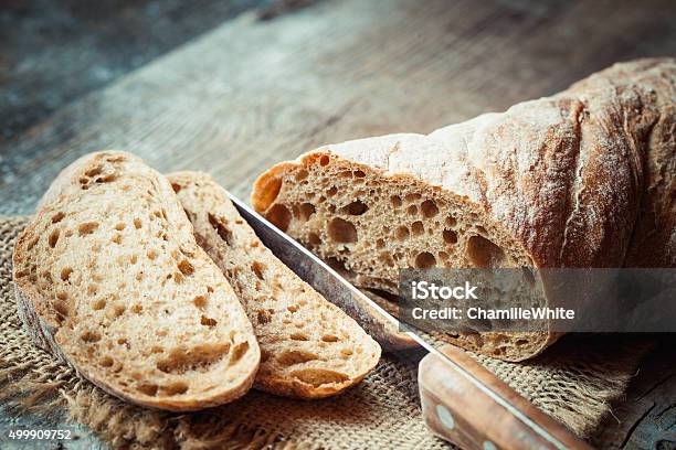 Fresh Bread Slice And Cutting Knife On Table Stock Photo - Download Image Now - Baguette, Baking, Bread