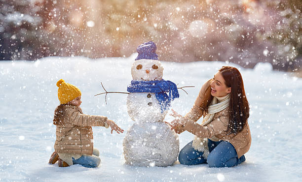 madre y niño chica en un paseo en la naturaleza de invierno - snowman snow winter fun fotografías e imágenes de stock