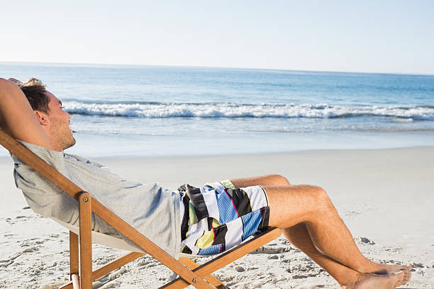 istock Handsome man lying on his deck chair admiring sea 499910887