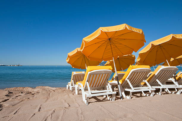 Bright yellow umbrellas on a sand beach in Cannes, France
