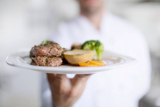 Male chef showing food